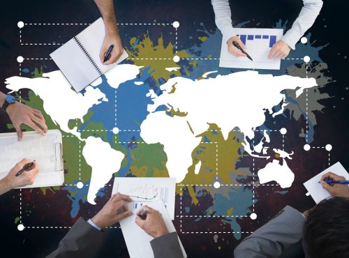 business hands working with papers colorful map with paint splatters wall background scaled