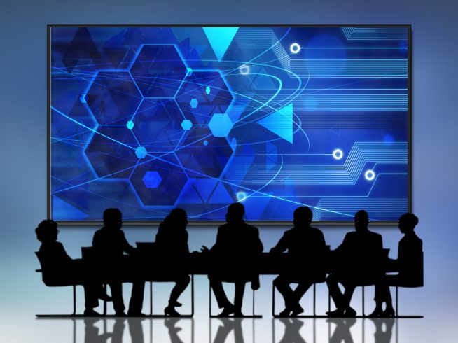 people sitting conference room watching screen with word cloud it